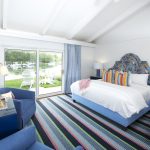 bed with blue headboard and striped pillows harborfront bunglaow with patio overlooking kennebunk river at yachtsman hotel marina club bar kennebunkport maine
